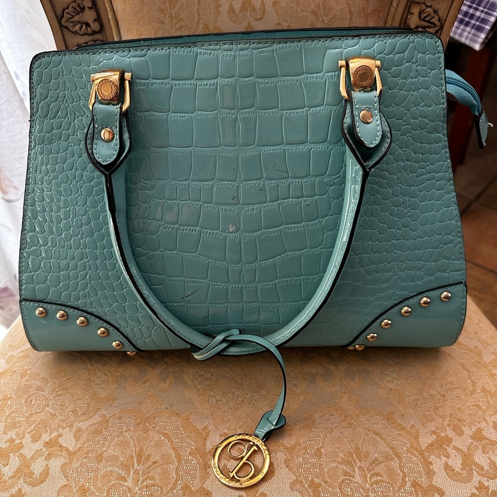 Faux crocodile handbag with designer charm and hardward.